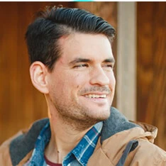 A man with a goatee smiles at the camera